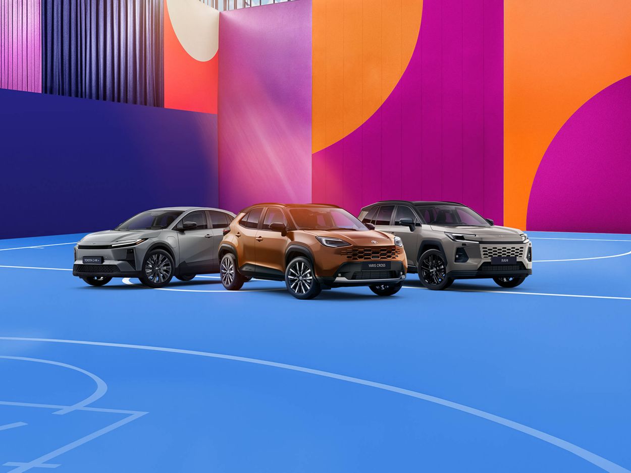 Vier Toyota SUV-Modelle nebeneinander vor einem farbigen, grafischen Hintergrund