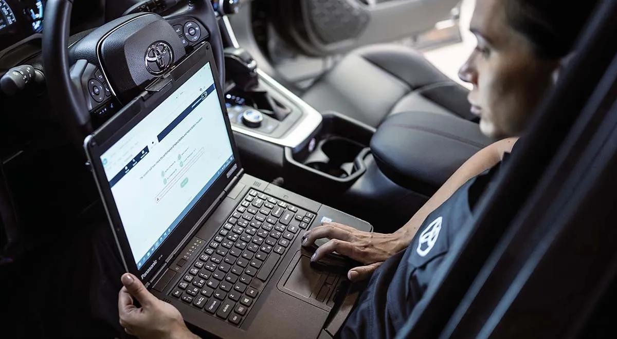Mann an einem Laptop im Auto